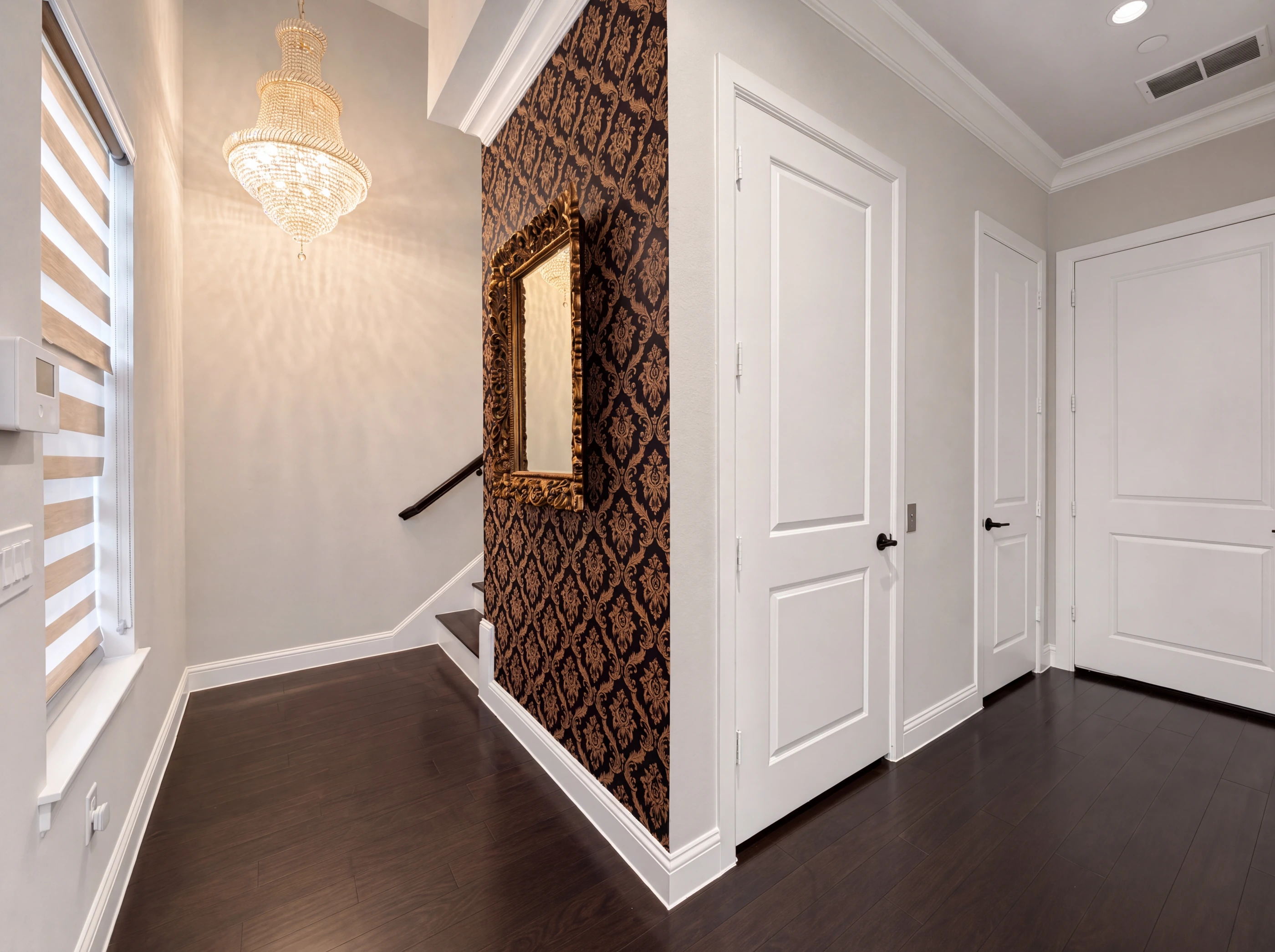 Entry with crystal chandelier and damask accent wall